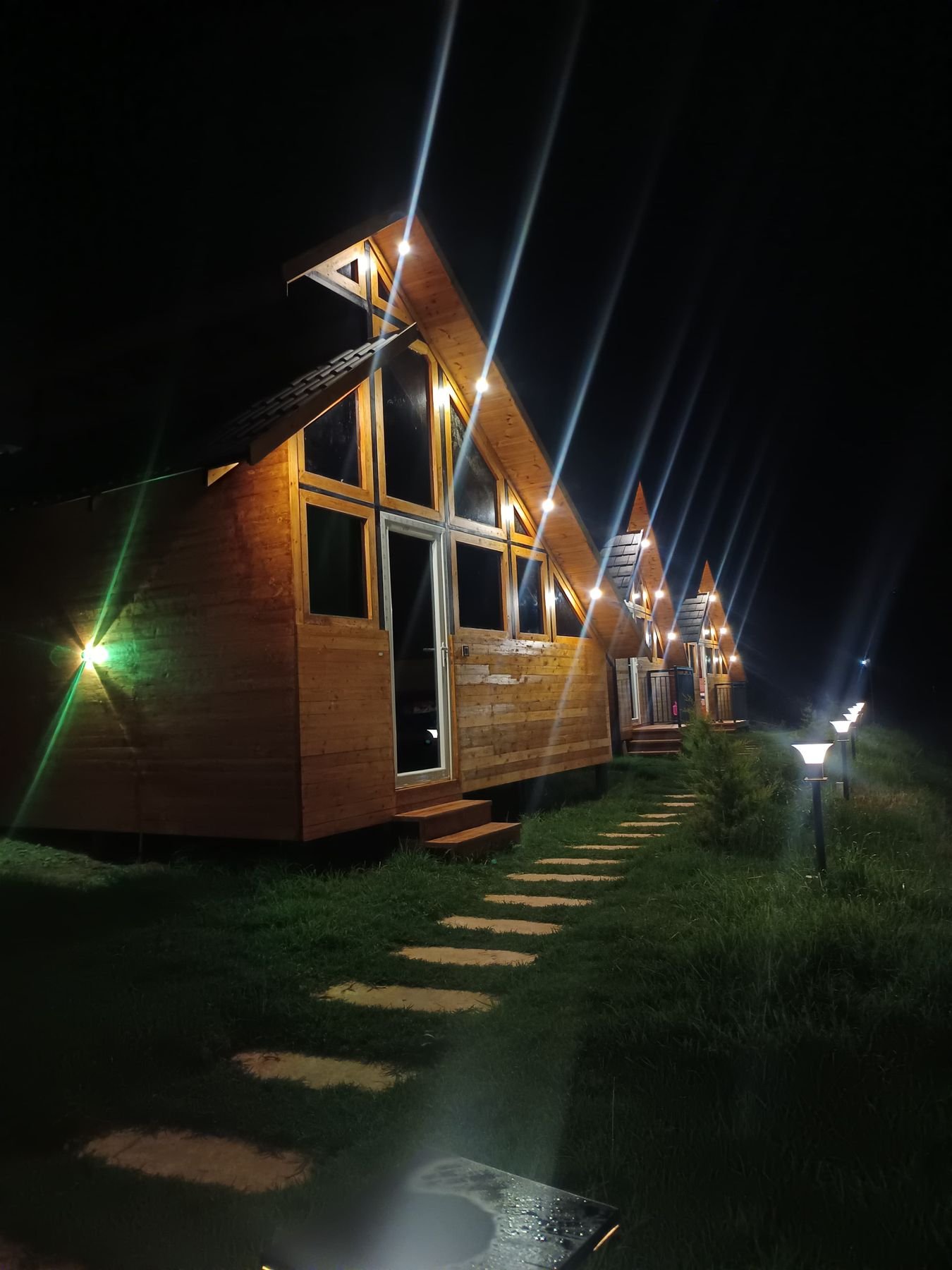A-frame cabins lit at night at Misty Meadows